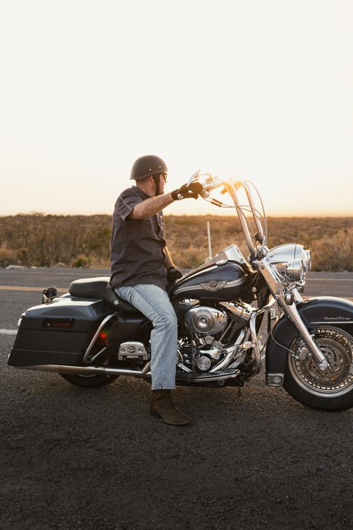 Free A motorcyclist enjoys a scenic ride on Route 66 in New Mexico as the sun sets. Stock Photo