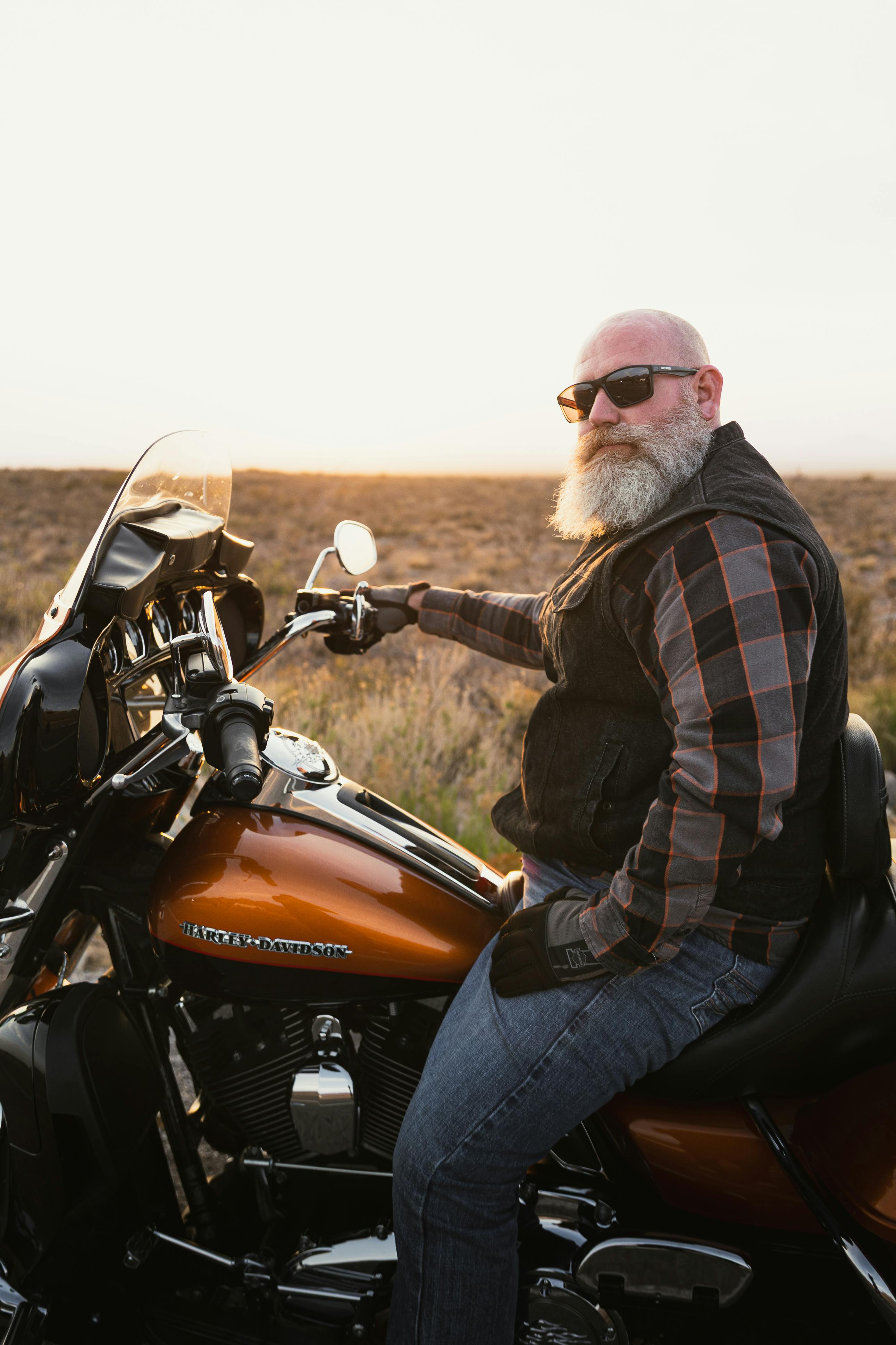 Biker rides Harley Davidson on Route 66 in New Mexico at a picturesque sunset.