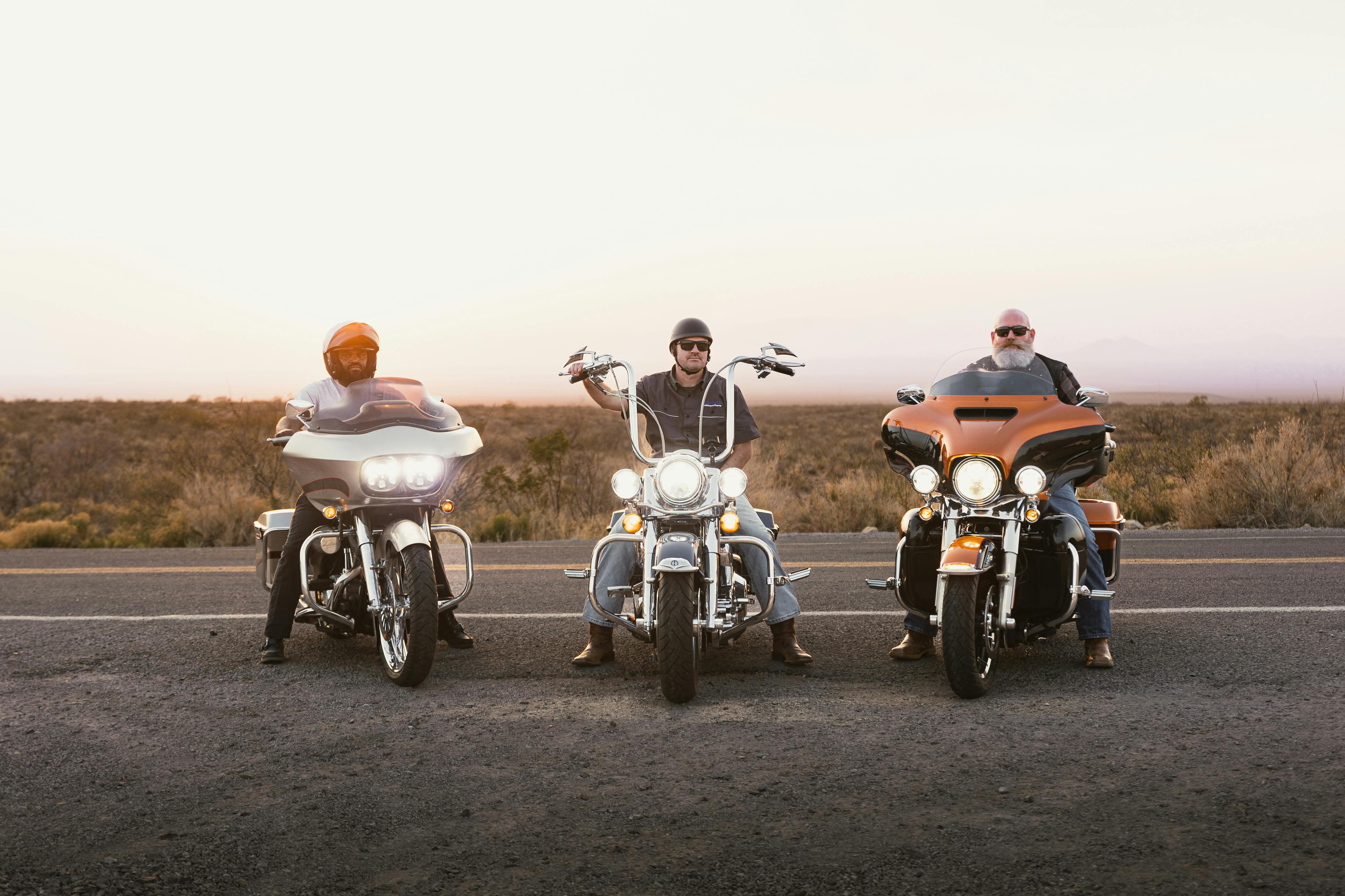 Three bikers on motorcycles on Route 66 at sunset, New Mexico desert.