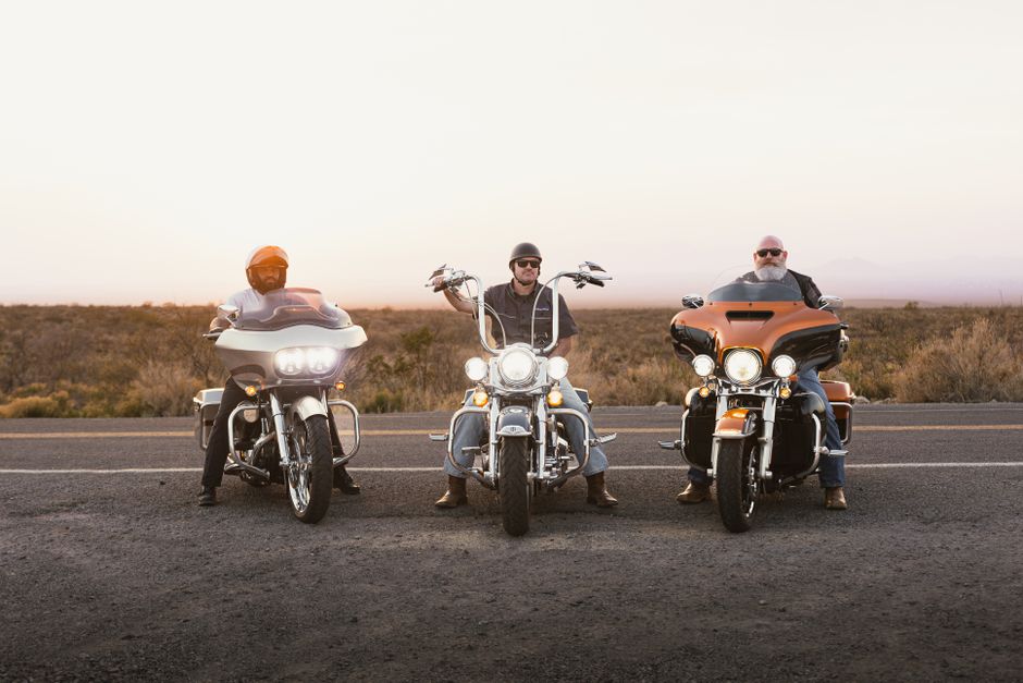 Geico vs Allstate: Motorcycle Insurance Rates for Sport Bikes & Cruisers Three bikers on motorcycles on Route 66 at sunset, New Mexico desert.