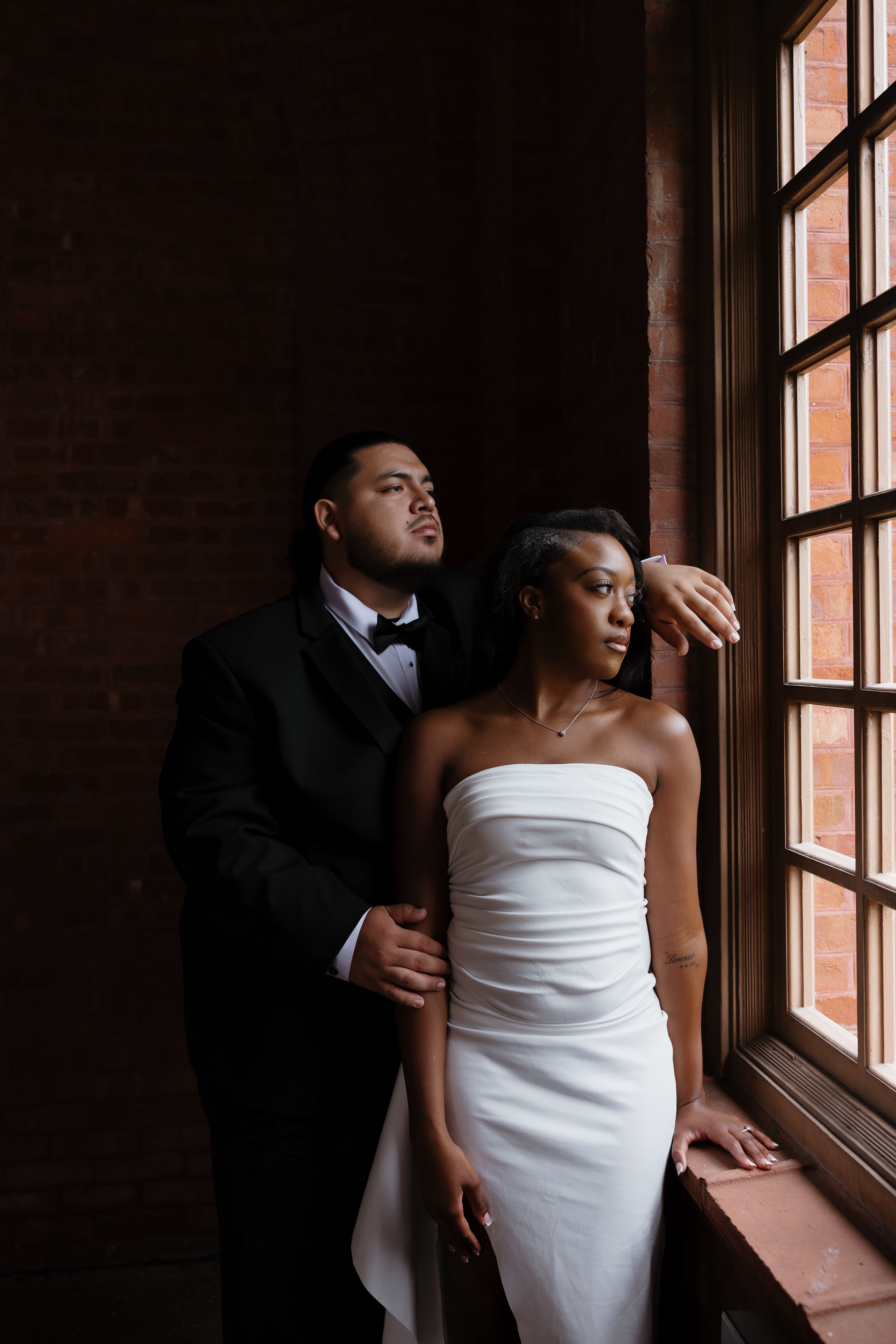 Elegant Couple Posing by Window in Formal Attire · Free Stock Photo