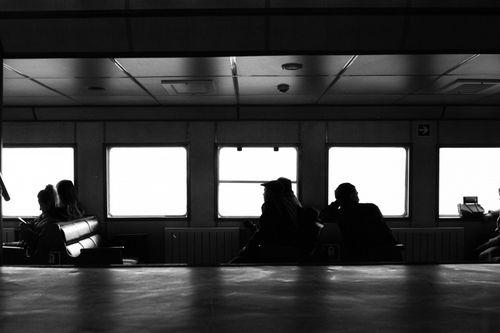 Free Black and white photo capturing passengers silhouetted against ferry windows in Istanbul. Stock Photo