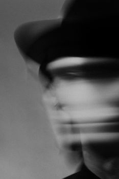 Monochrome portrait of a man with artistic motion blur, creating an abstract effect.