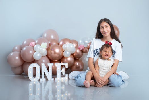 A happy family moment celebrating a child's first birthday with balloons.