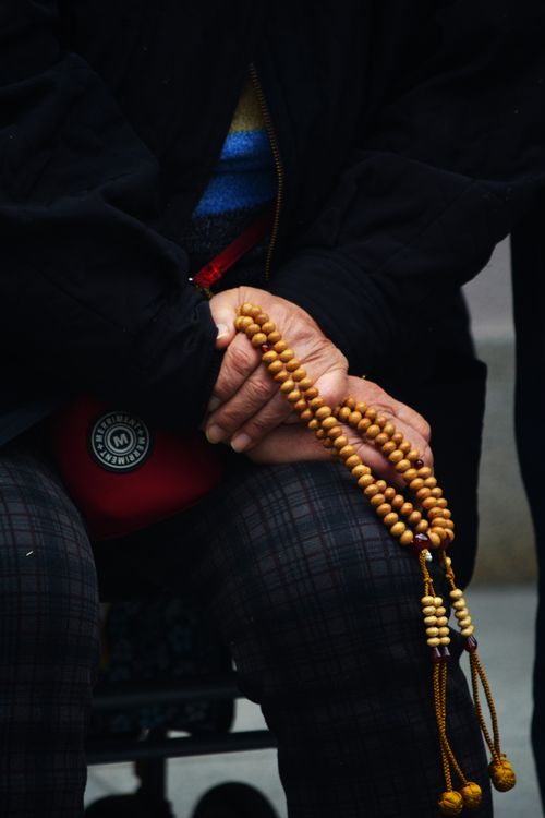Free Close-up of elderly hands holding prayer beads, symbolizing spirituality in Osaka, Japan. Stock Photo