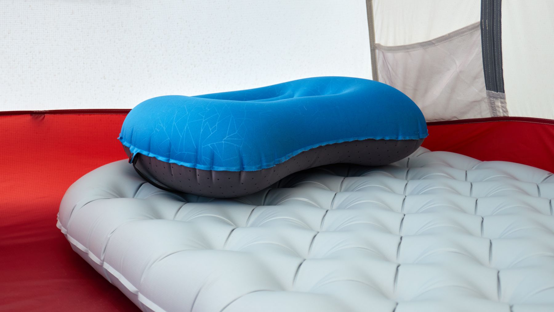 Close view of a camping pillow and sleeping pad prepared inside a tent