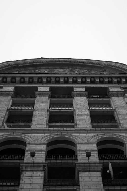 Free Black and white photograph showcasing a historic architectural facade with arches. Stock Photo