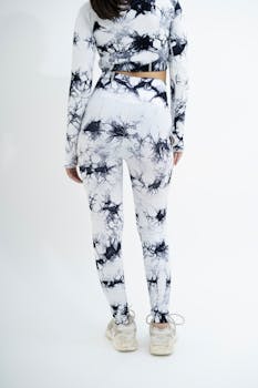 Back view of a woman in marble-patterned activewear against a plain background.