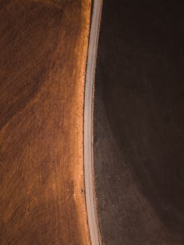 Scenic aerial view of a rural road dividing brown fields in Graz, Austria.