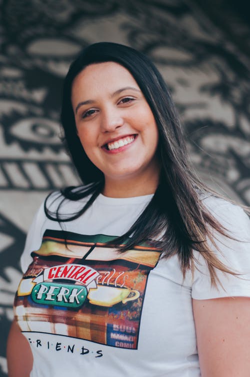 Foto De Foco Seletivo De Mulher Sorridente Em Uma Camiseta Branca Posando