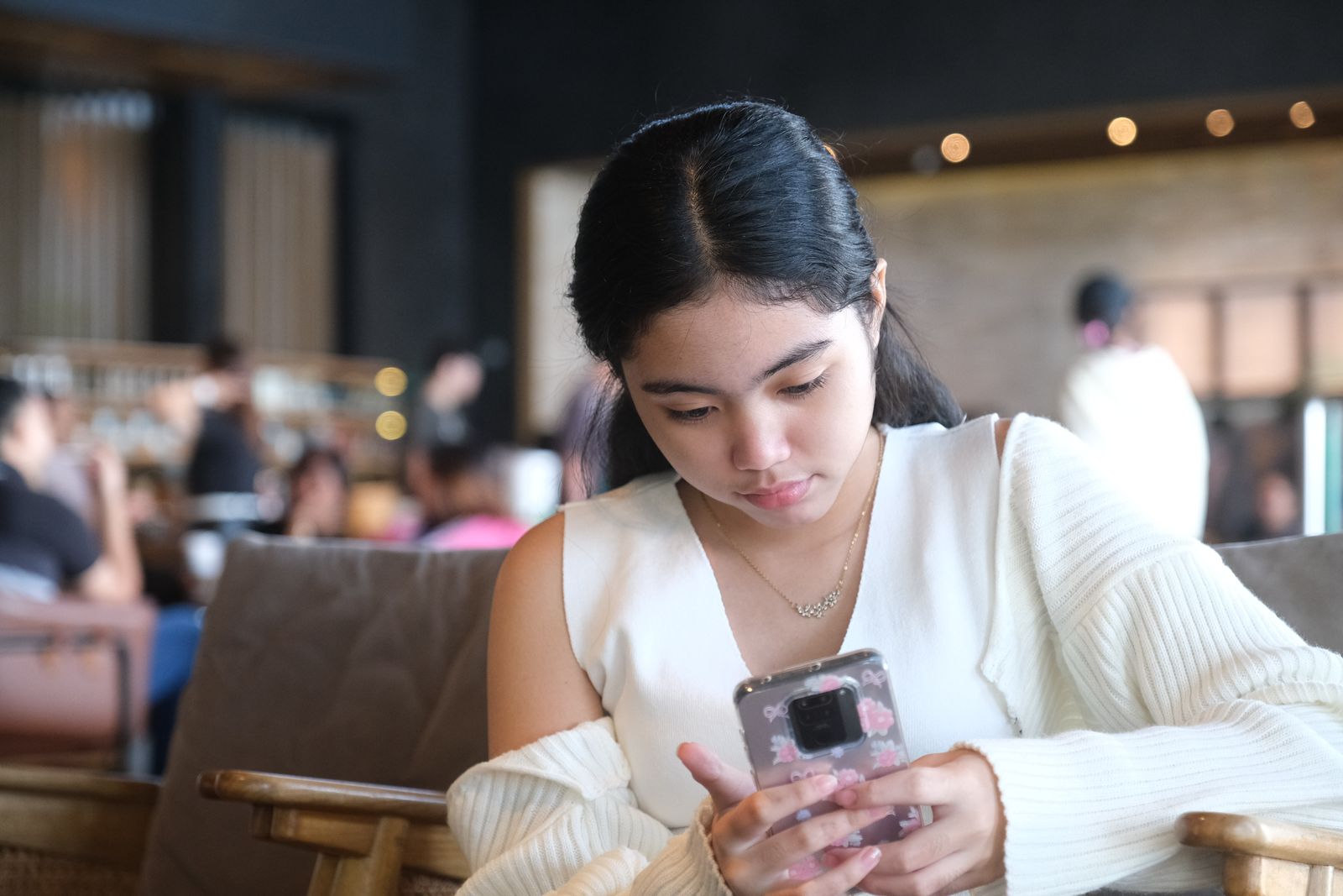 Mulher jovem utilizando um telefone celular em ambiente contemporâneo