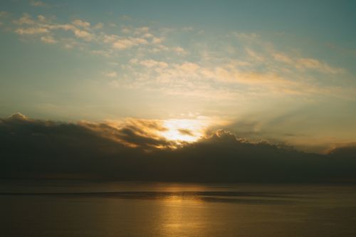 Free Golden sunrise over the calm sea, casting a serene reflection on the water in Vietnam. Stock Photo