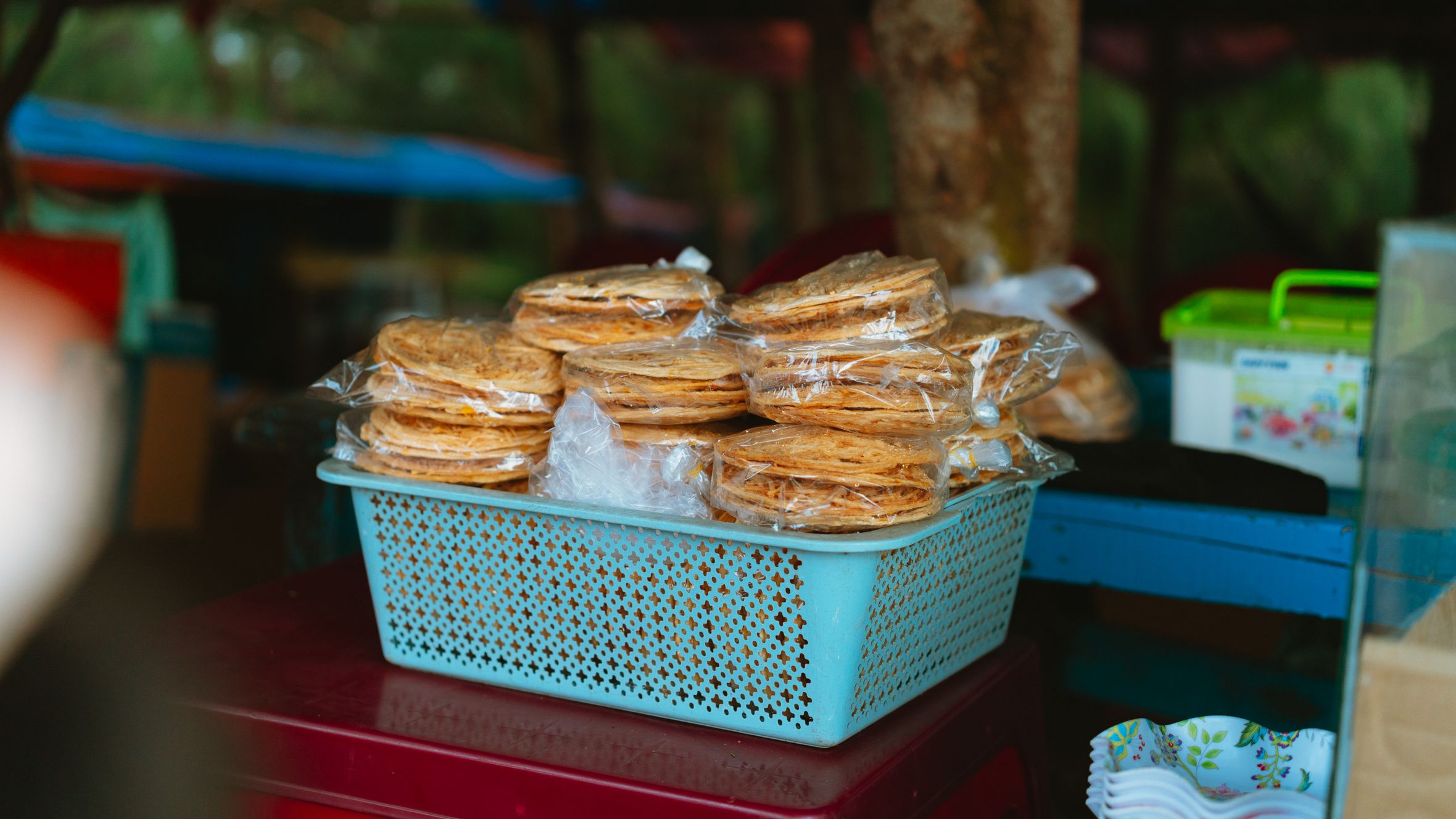 Stacked Vietnamese snacks wrapped in plastic at Bình Thuận market.