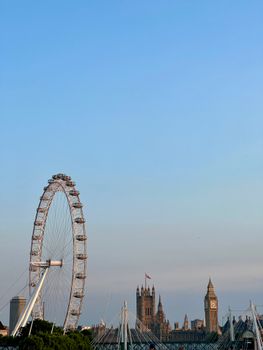 Stunning view of Big Ben and the London Eye against a clear blue sky. Perfect for travel and architecture enthusiasts.