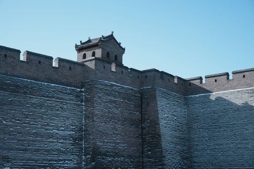 Free Photograph of an ancient stone fortress with snow on its walls against a bright blue sky. Stock Photo
