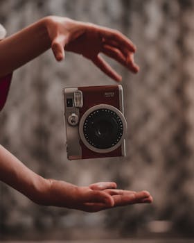 一台老式即时相机在双手之间漂浮，展现出创造力和悬浮感