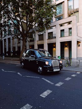 Iconic black taxi parked on a city street in London, capturing urban architecture.