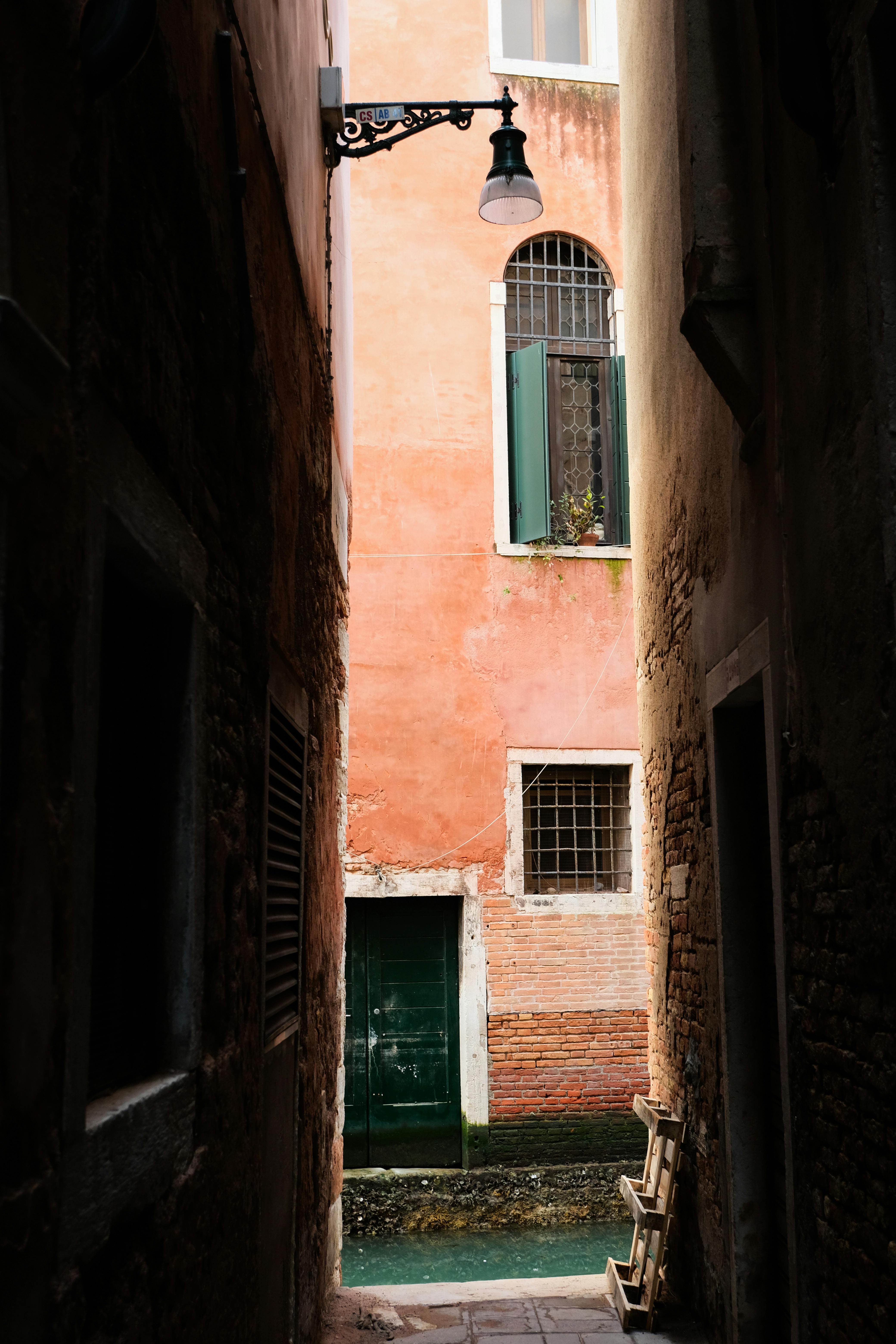 Capture of a narrow alleyway in Venice showcasing traditional Venetian architecture with vibrant colors.