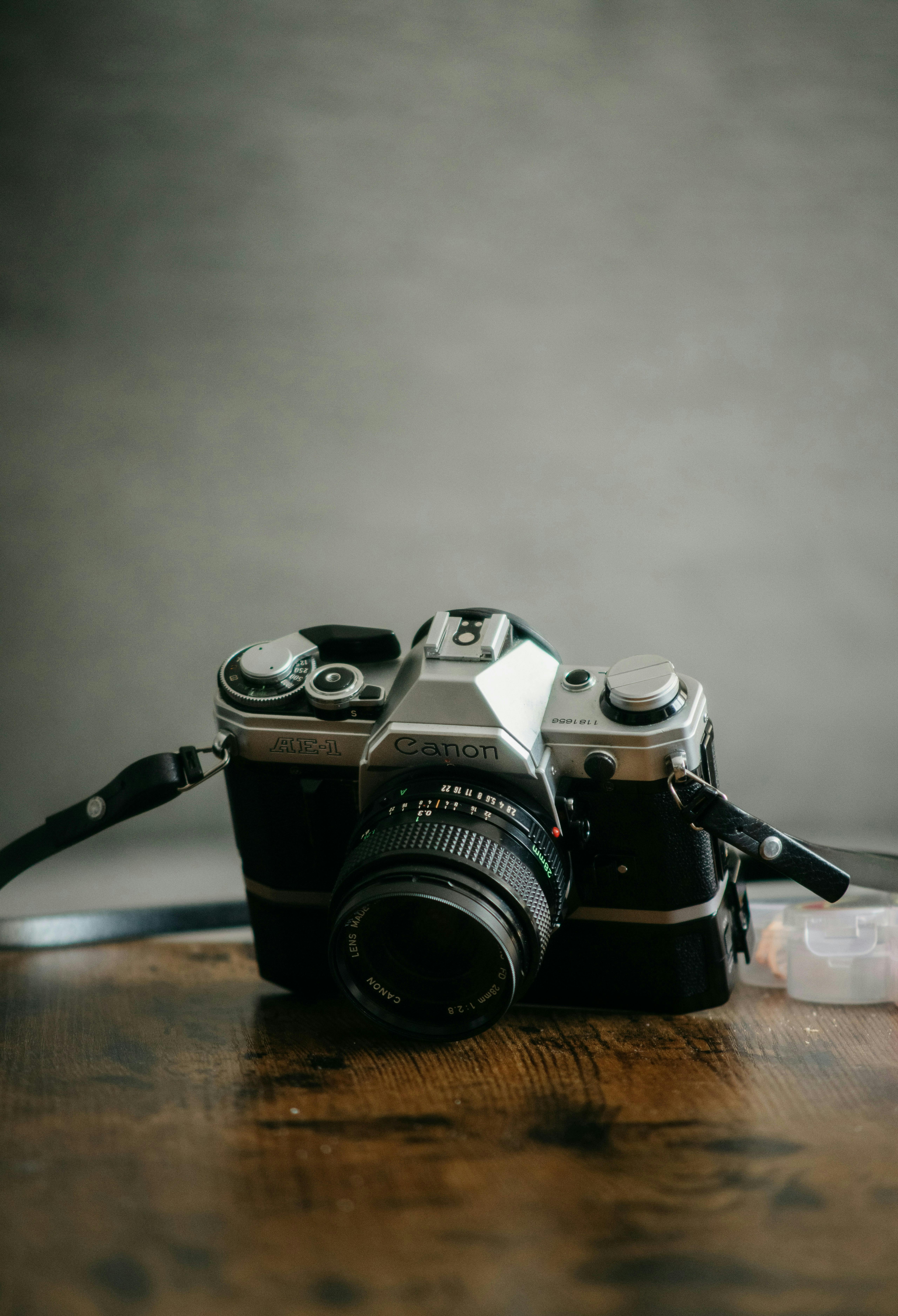 A classic vintage 35mm SLR camera resting on a wooden surface, capturing nostalgia.