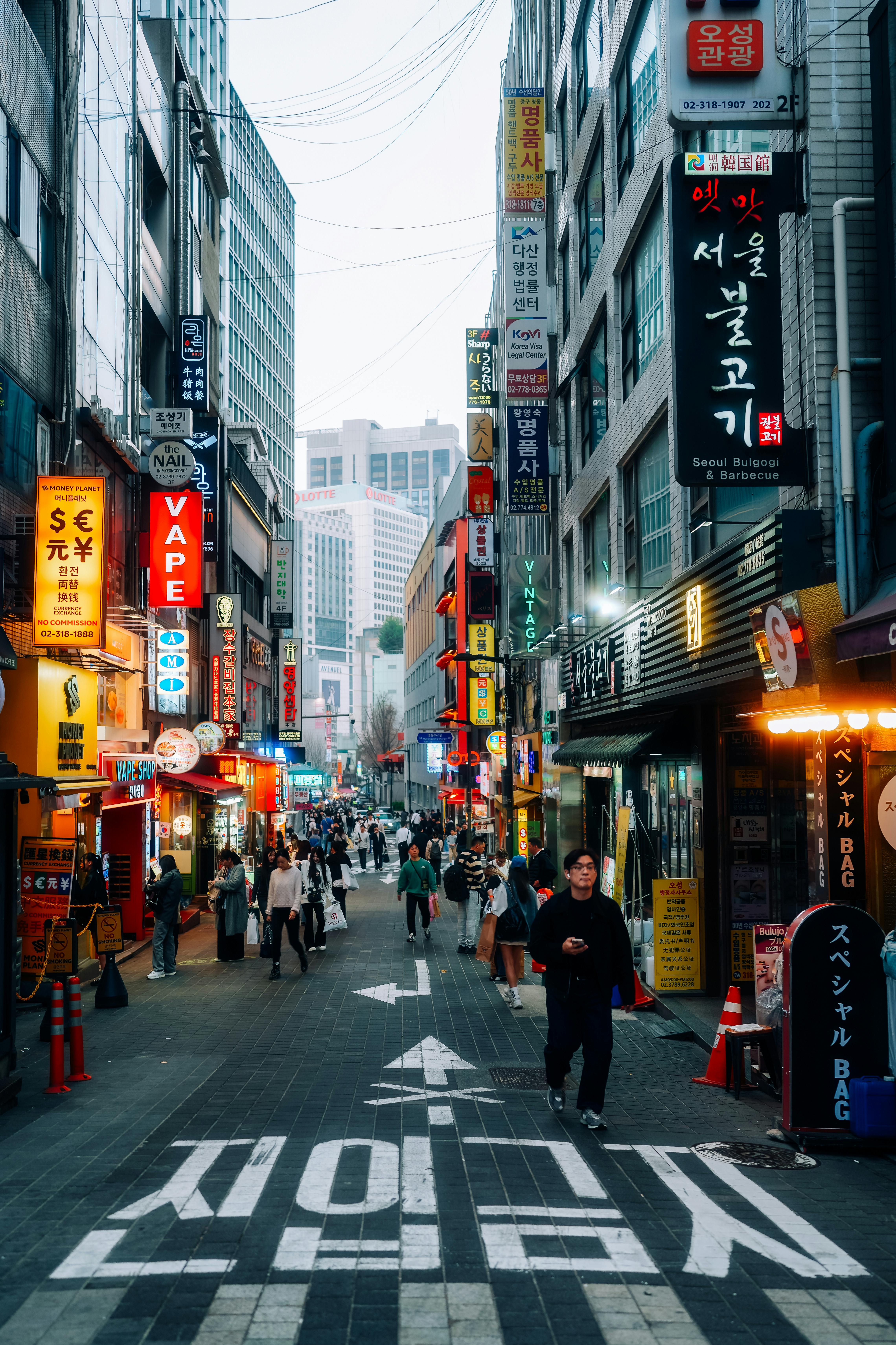Bustling street scene in Seoul, South Korea with vibrant signs and people strolling.