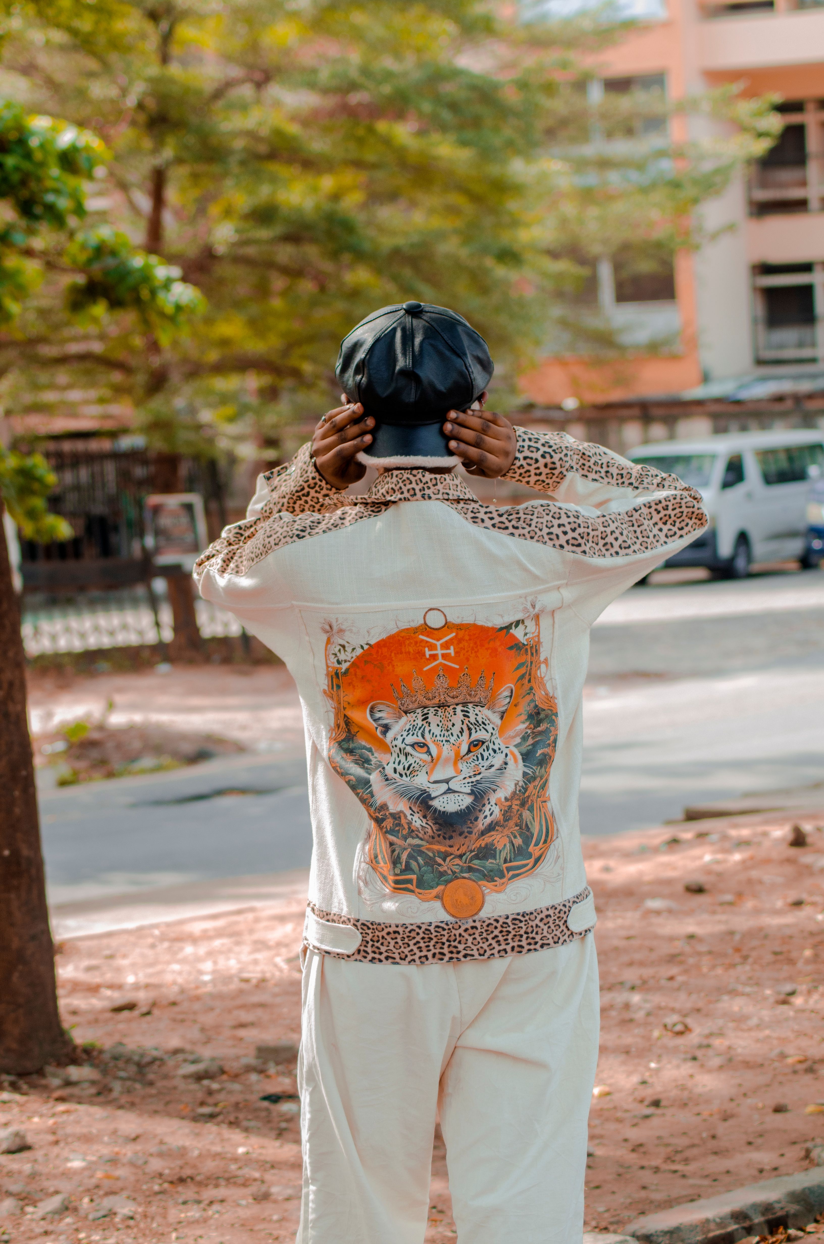 Man in fashionable outfit with a tiger print jacket outdoors.