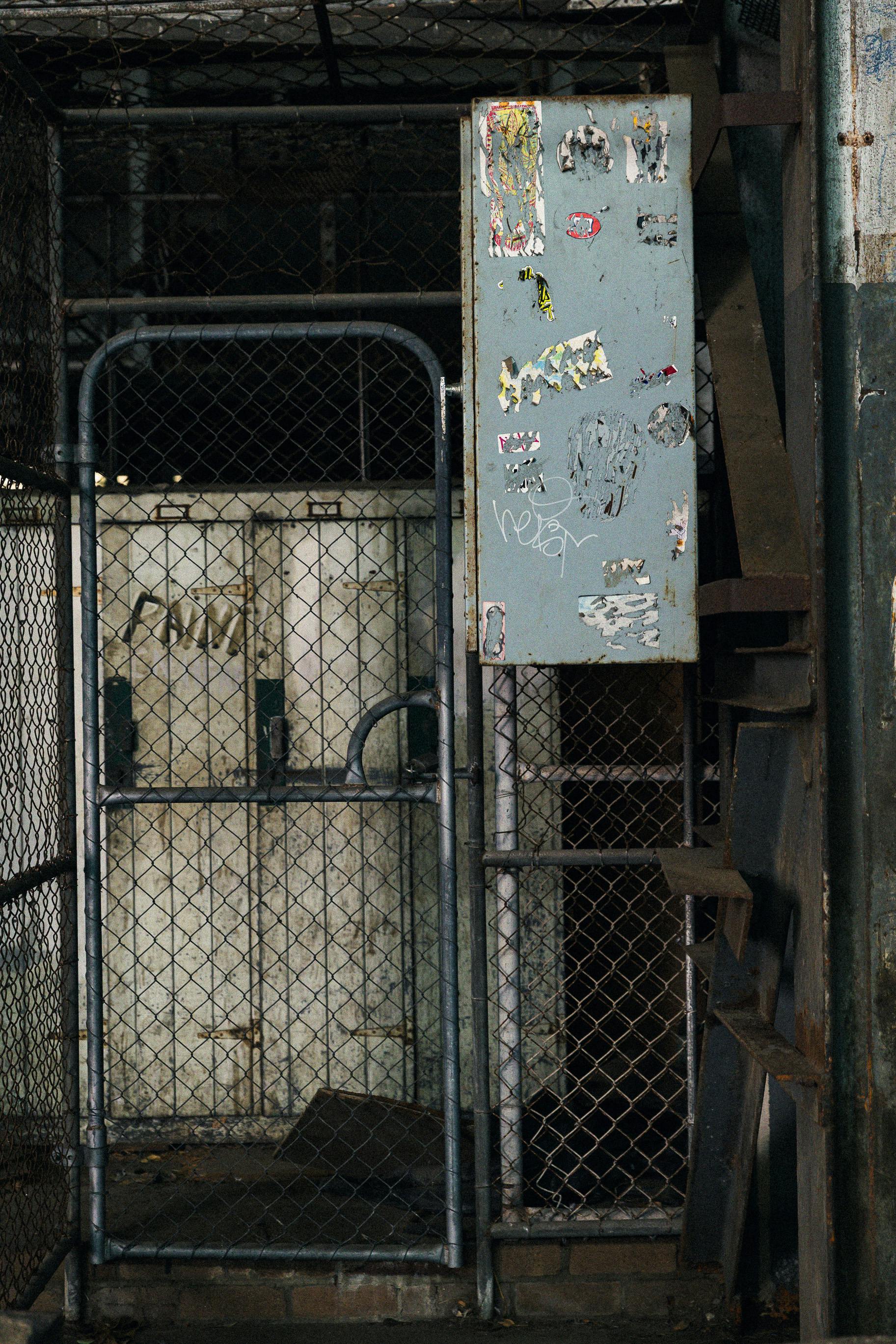 grátis Cena industrial com portão de metal e grafite, mostrando a decadência urbana. Foto profissional