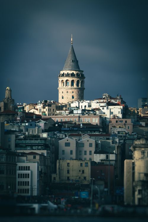 Free Dark, atmospheric view of Galata Tower in Istanbul surrounded by city buildings. Stock Photo