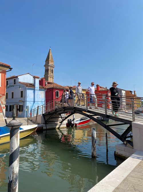 Free Tourists on a bridge over a colorful canal in Burano, Venice, Italy. Stock Photo