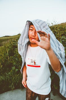 一个年轻人随意打扮，头上披着件衬衫，在户外享受夏日时光