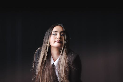 Sophisticated portrait featuring an elegant woman in monochrome fashion with a confident expression.