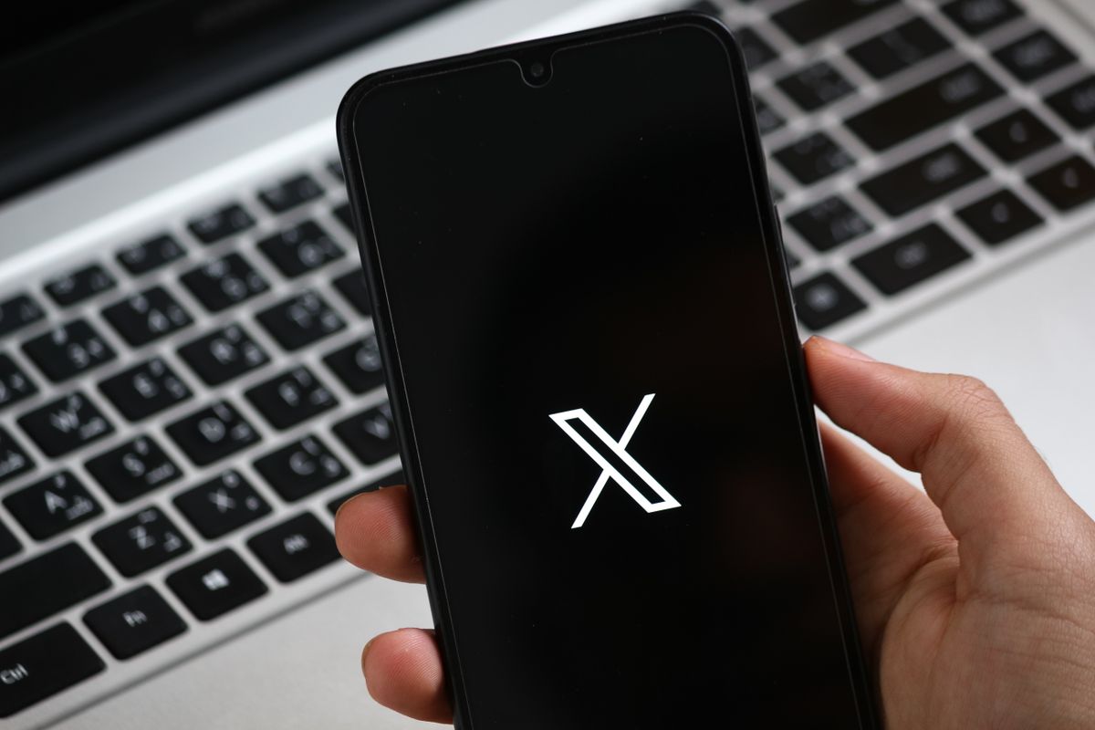 Une main tient un smartphone affichant une interface d'application