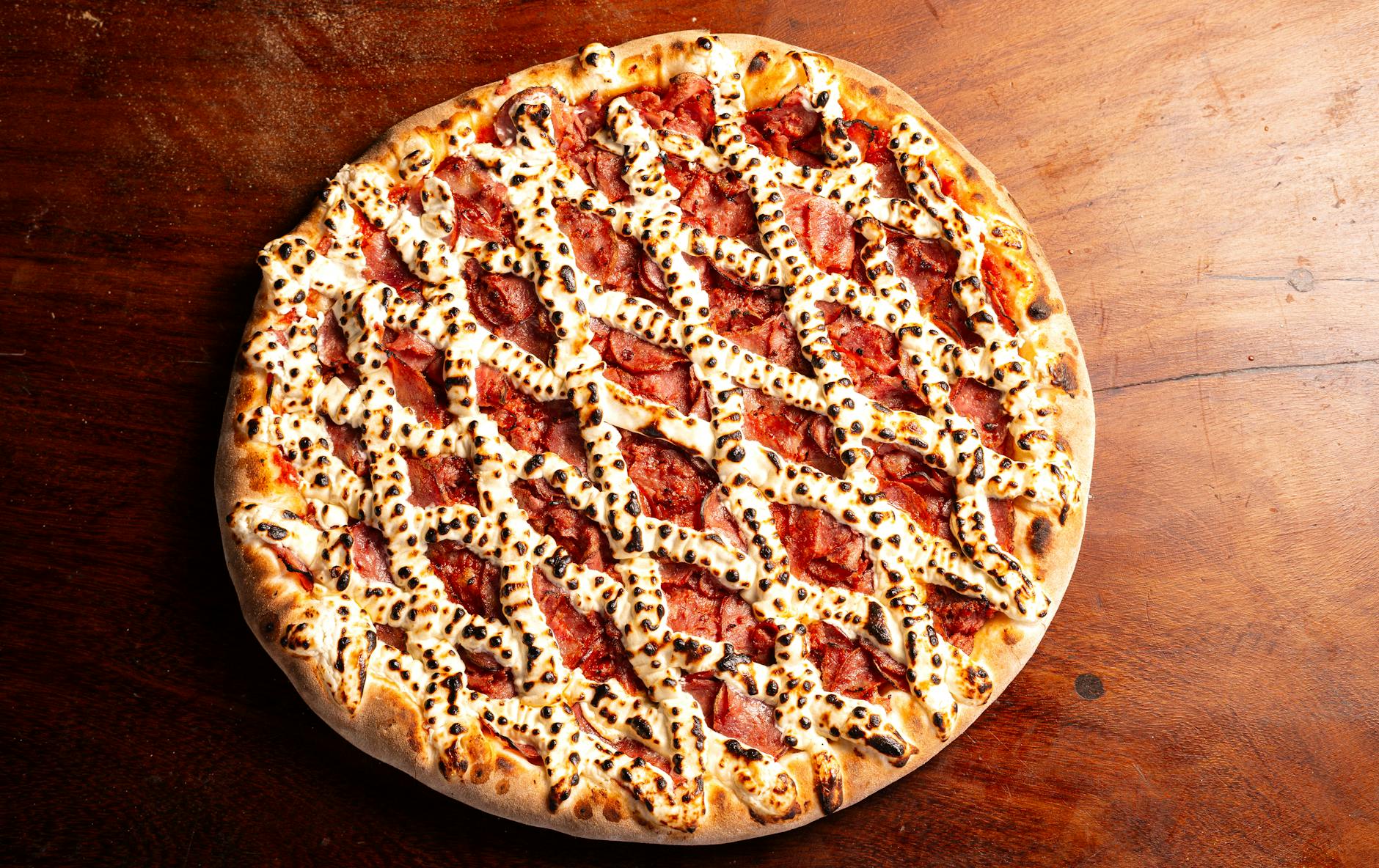 Mouthwatering pepperoni pizza topped with golden melted cheese on a rustic wooden table.