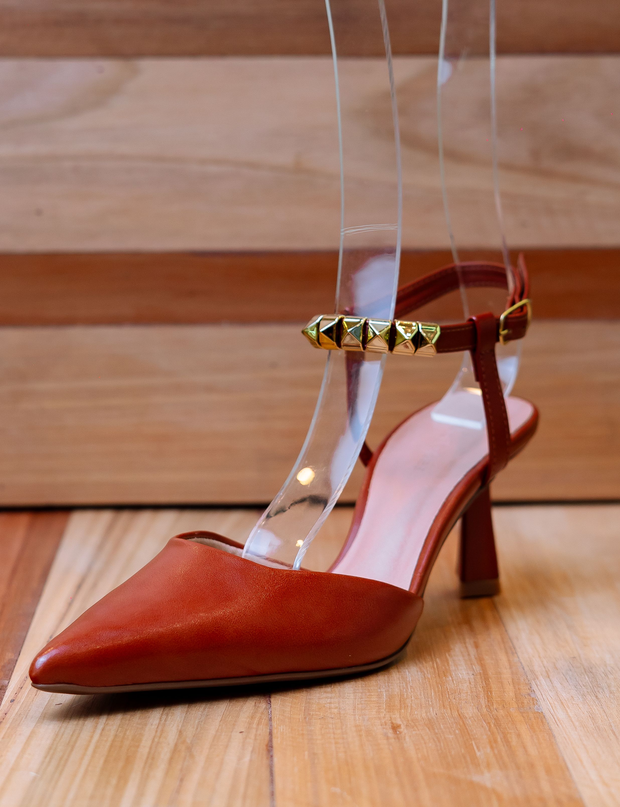 Fotomural Zapato de tacón alto marrón elegante con tachuelas doradas, perfecto para exhibiciones de moda y estilo.