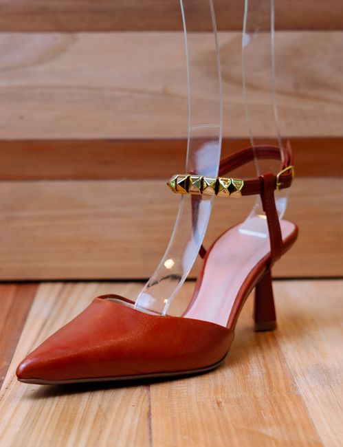 Fotomural Zapato de tacón alto marrón elegante con tachuelas doradas, perfecto para exhibiciones de moda y estilo.