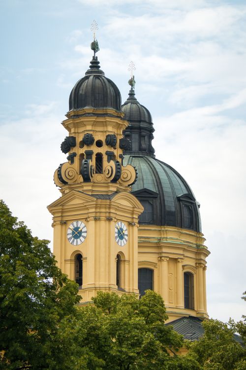 Free Elegant Baroque towers of Theatine Church stand against a soft blue sky in Munich. Stock Photo