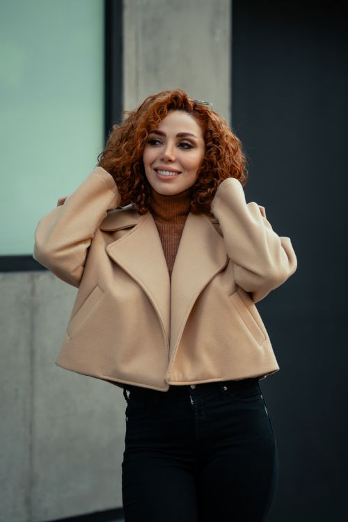 Free A fashionable woman with curly hair poses confidently outdoors in Tehran. Stock Photo