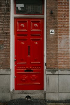 Red door on a charming Amsterdam brick building facade.