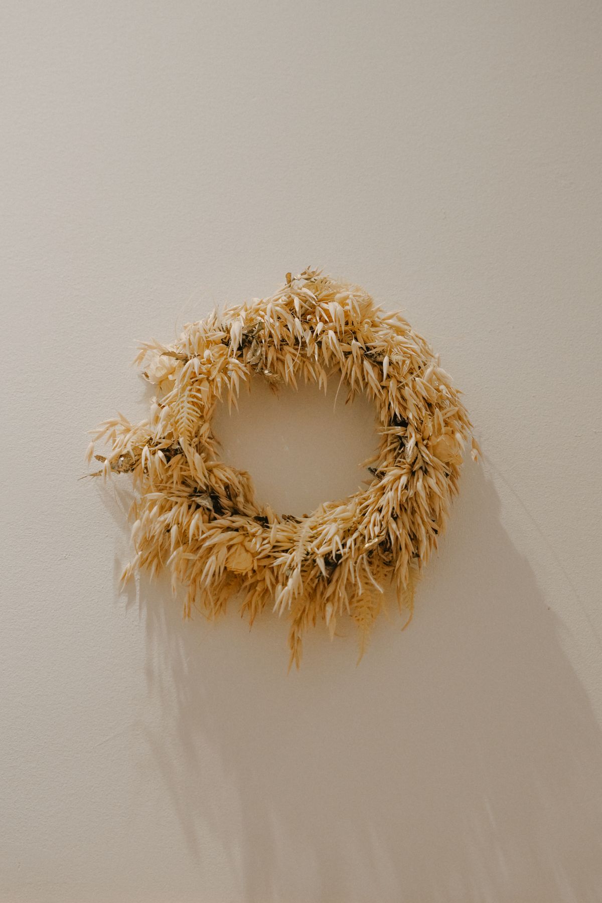 Rustic dried wheat wreath displayed on a neutral wall
