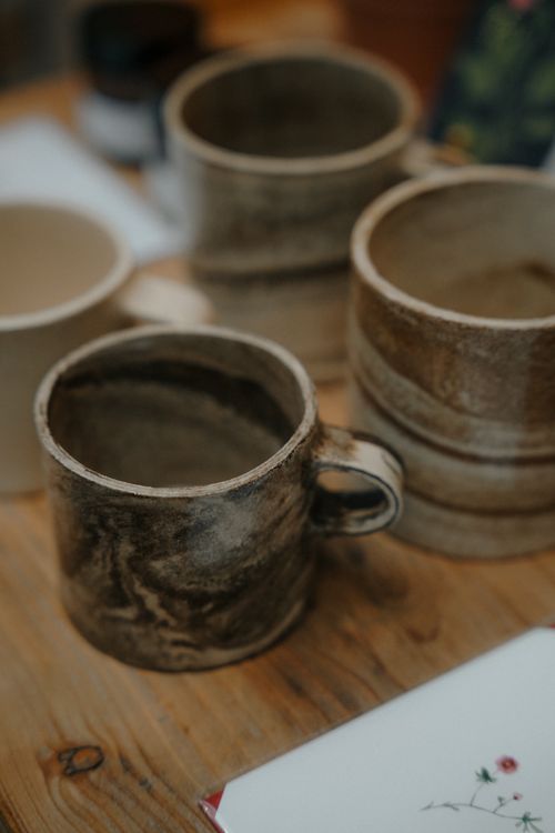 Handcrafted ceramic mugs on a rustic wooden table — photo by Mathias Reding on Pexels