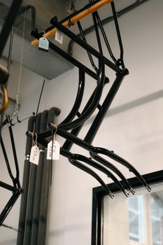 Hanging black steel bicycle frames in an Amsterdam workshop with natural lighting.