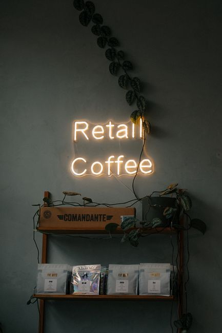 Cozy coffee shop setup with neon sign and retail display in Amsterdam.