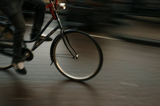 Blurred motion photo of a cyclist riding through Amsterdam, capturing urban speed and energy.