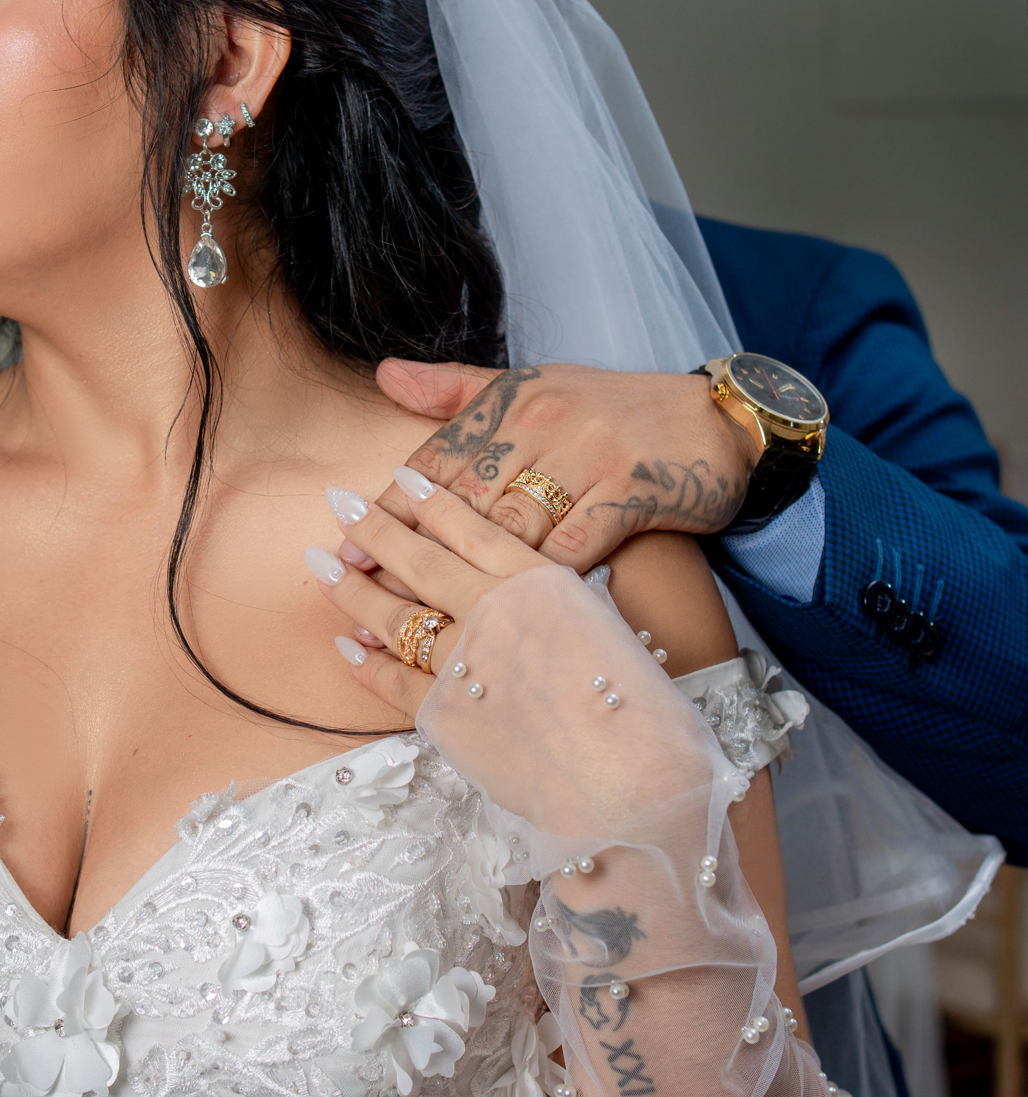 Close-up of a wedding couple sharing a tender moment, highlighting rings and jewelry.