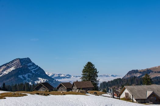 Beautiful mountain view with alpine cabins and snow in Wildhaus-Alt Sankt Johann, Sankt Gallen, Switzerland.