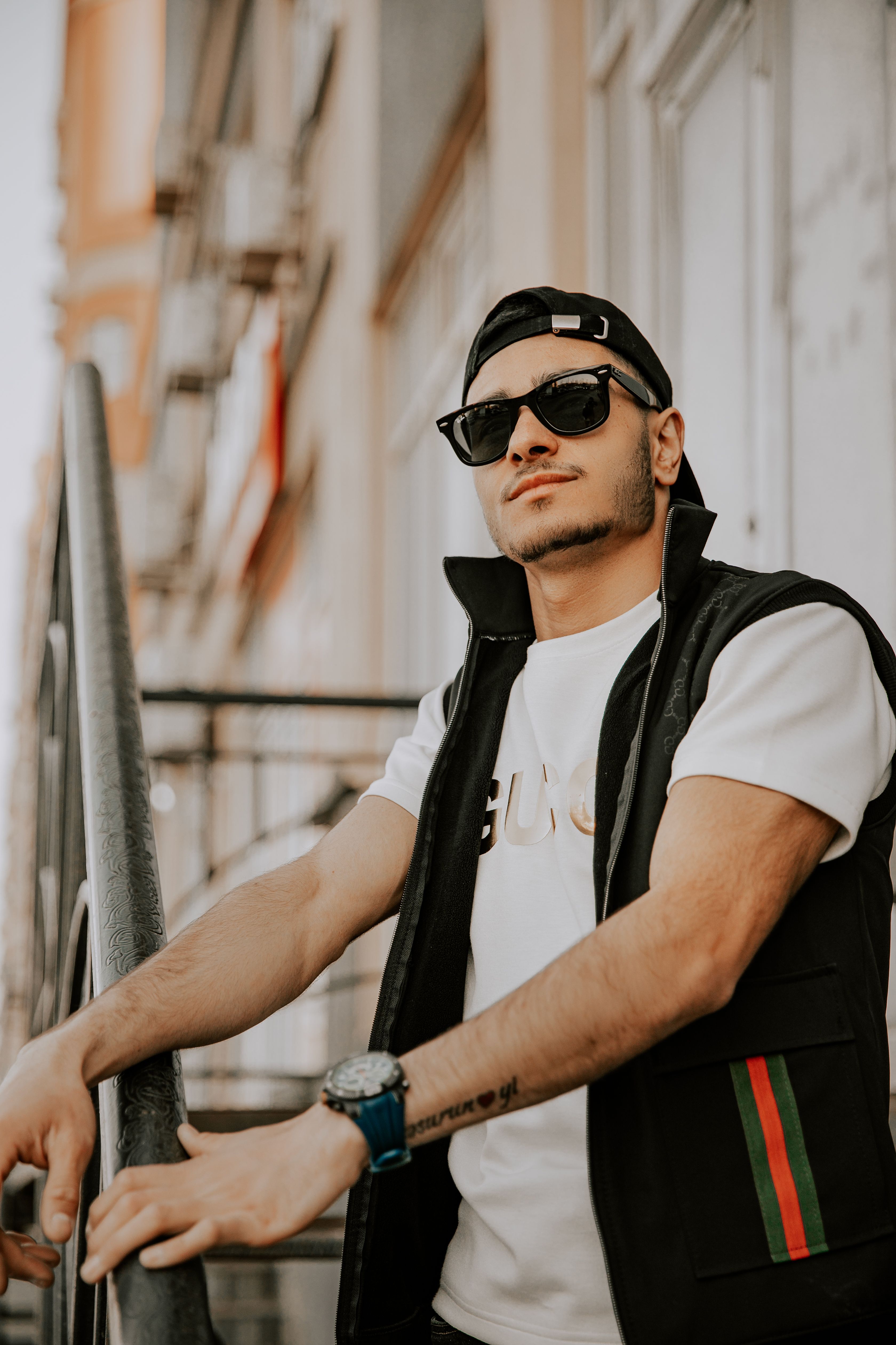 Trendy young man in sunglasses posing on a city street in Baku, showcasing urban style.