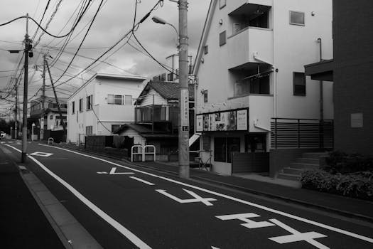 Black and white photograph of an empty street in Tokyo, Japan, capturing urban architecture and electric wires.