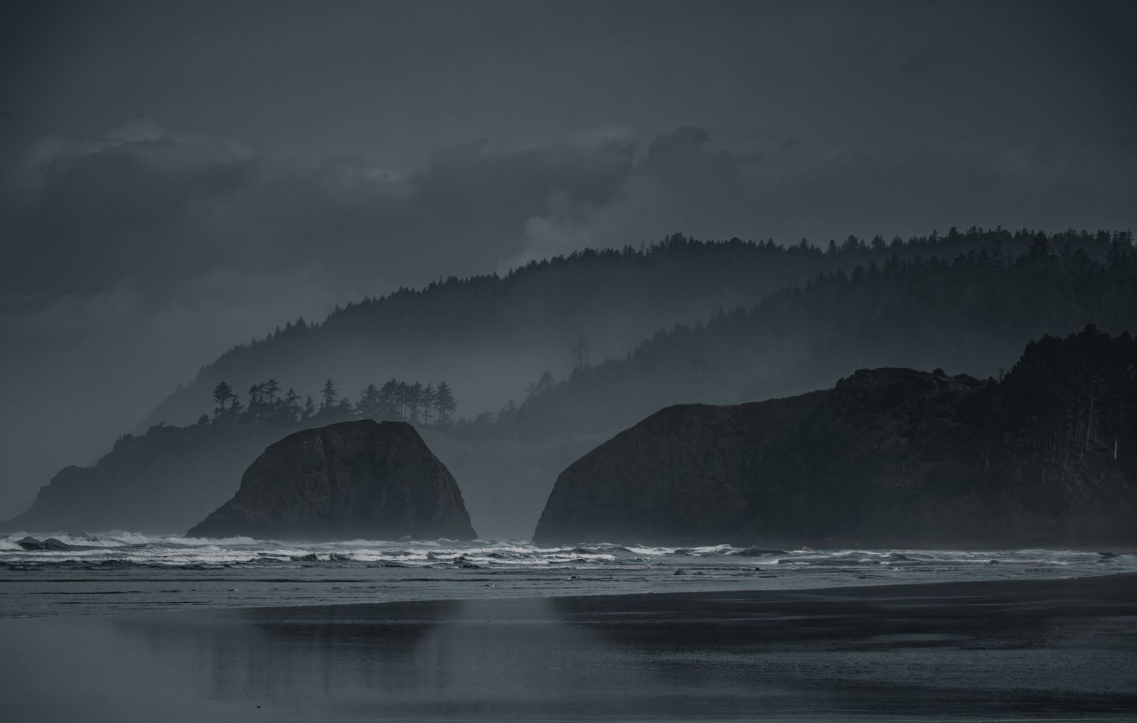 Misty coastal cliffs under a dark sky — photo by Mik Dominguez on Pexels