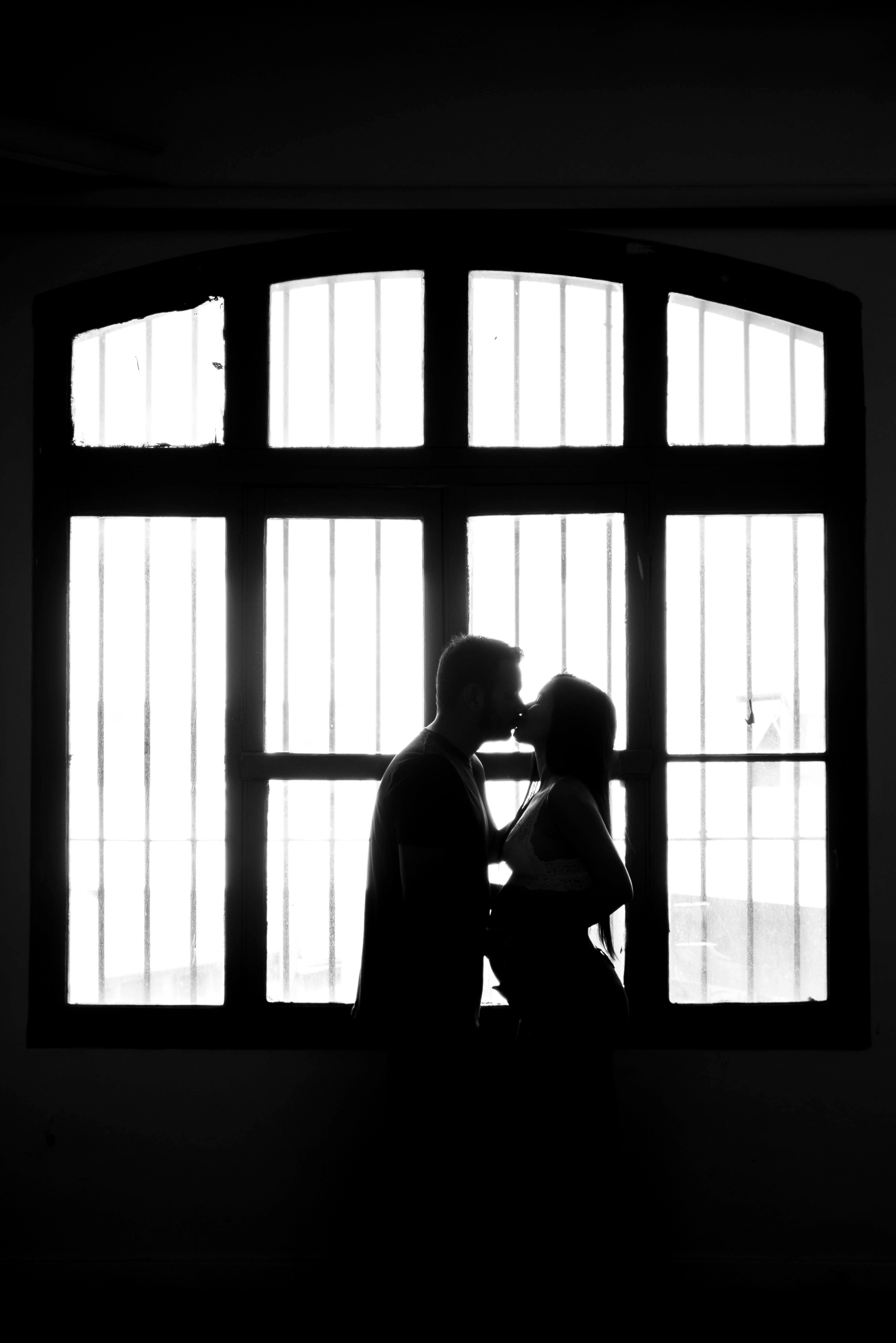 Silhouette of Couple in Romantic Embrace by Window · Free Stock Photo