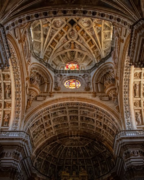 Free Stunning architectural ceiling inside Granada Cathedral, highlighting Renaissance details and stained glass. Stock Photo