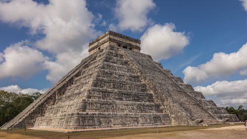 Free Stunning view of the iconic Chichen Itza pyramid in Mexico against a backdrop of beautiful clouds. Stock Photo